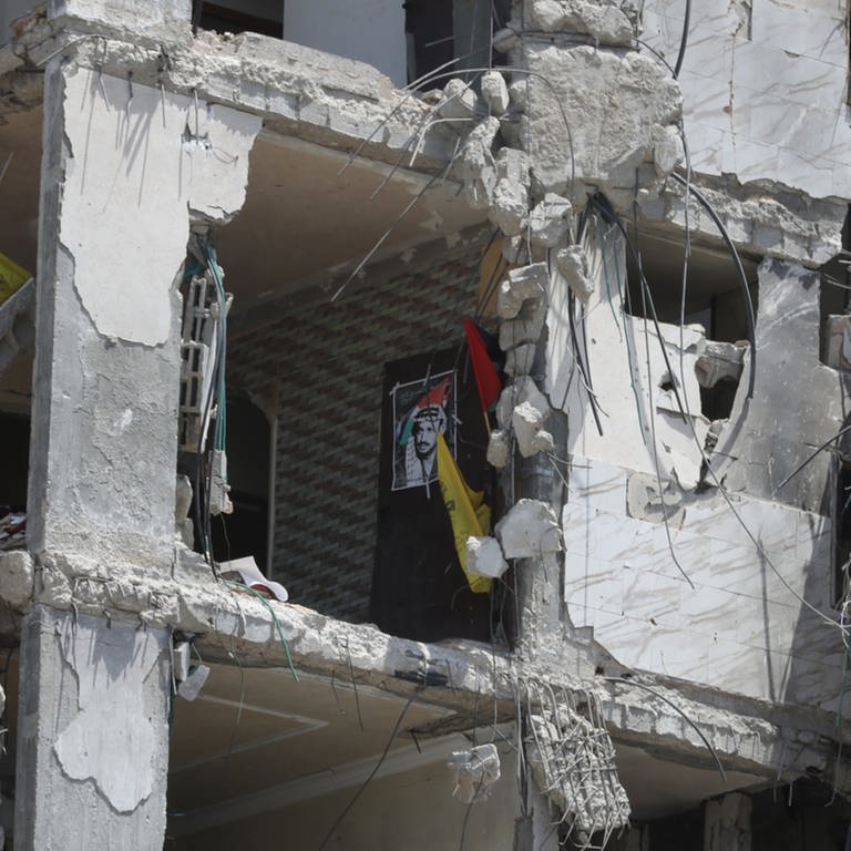  Ein Plakat und Fahnen hängen in einem zerstörten Gebäude im Norden eines Flüchtlingslagers im Gazastreifen (Archivbild). (Foto: dpa)